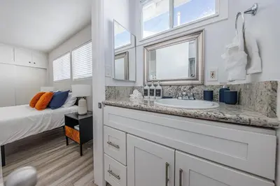 a bathroom with a sink and a bed with windows at Spacious 2-Bedroom Duplex in Beverly Hills Residential Area in Los Angeles