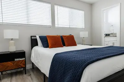 a bedroom with a bed with orange and blue pillows at Spacious 2-Bedroom Duplex in Beverly Hills Residential Area in Los Angeles