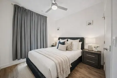 a white bedroom with a large bed and a window at Casa Blanca Coastal Condo Rooftop Heated Pool in Los Angeles