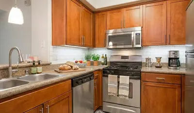 a kitchen with stainless steel appliances and wooden cabinets at Demo1 in Los Angeles