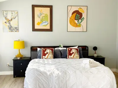 a bedroom with a bed with four pictures on the wall at 3000sqft Modern Minimal 5BR3BA Home Near ONT in Ontario