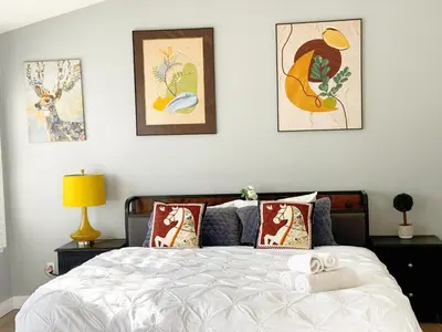 a bedroom with a bed with four pictures on the wall at 3000sqft Modern Minimal 5BR3BA Home Near ONT in Ontario