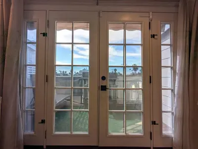 a window with white doors with a view at Walk 2min to BEACH! Boho 3-Bedroom BEACH Pad with AC, Patio, Laundry & Mid Size Parking in Long Beach