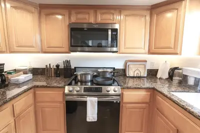 a kitchen with a stove and a microwave at Walk 2min to BEACH! Boho 3-Bedroom BEACH Pad with AC, Patio, Laundry & Mid Size Parking in Long Beach
