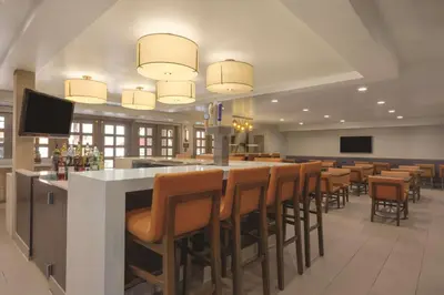 a restaurant with a bar with brown chairs at Hyatt House Cypress / Anaheim in Cypress