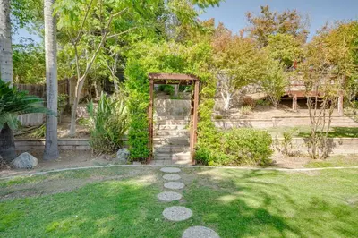 a garden with a wooden gate in the grass at Your Poolside Hideaway in Bakersfield