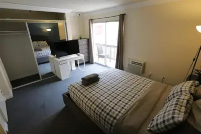 a bedroom with a bed and a television in it at Beverly Hills Queen Bed Studio in Los Angeles