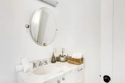 a white bathroom with a sink and a mirror at Charming 2BR 2BA Los Angeles Home with Character in Sherman Oaks Community Hospital Heliport