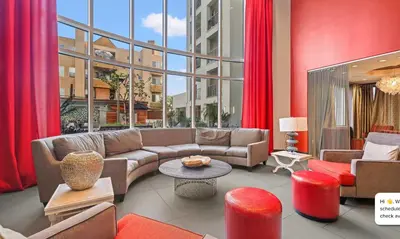 a living room with a couch and a large window at Modern 2BR at the Huxley Prime West Hollywood Location in Los Angeles