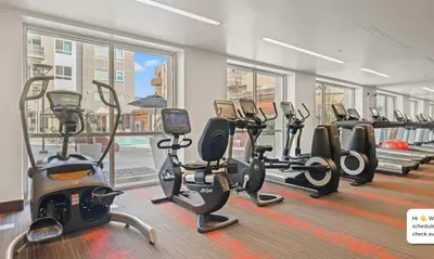 a gym with rows of exercise bikes and treadmills at Modern 2BR at the Huxley Prime West Hollywood Location in Los Angeles