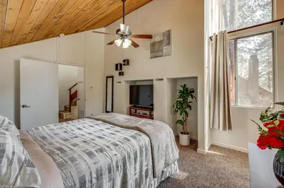 a bedroom with a bed and a ceiling fan at 5 Mi to Mountain High Resort Home with Gaming Area in Wrightwood
