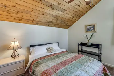 a bedroom with a bed and a wooden ceiling at 5 Mi to Mountain High Resort Home with Gaming Area in Wrightwood