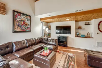 a living room with a leather couch and a tv at 5 Mi to Mountain High Resort Home with Gaming Area in Wrightwood