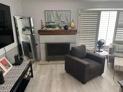 a living room with a chair and a fireplace at Beach Sweet condo home in Los Angeles