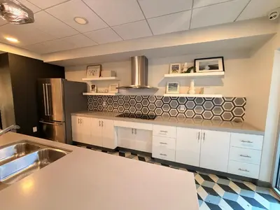 a large kitchen with white cabinets and a refrigerator at Hollywood Studio with Pool, Parking, Gym & Sign View in Los Angeles