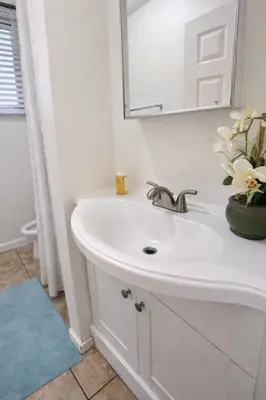 a white bathroom with a sink and a mirror at Charming Studio in the Heart of Hollywood in Los Angeles