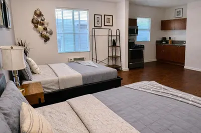 a bedroom with two beds and a kitchen at Compact Hollywood Studio in Los Angeles