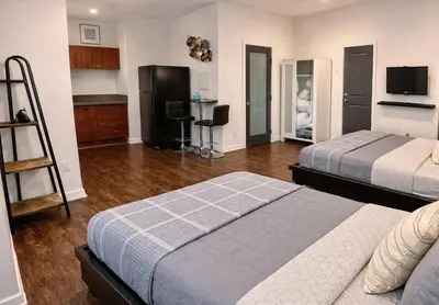 a hotel room with two beds and a kitchen at Compact Hollywood Studio in Los Angeles