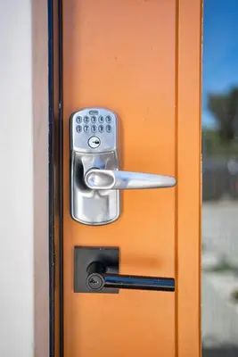 an orange door with a metal handle on it at 5BR Gorgeous Melrose Villa with Parking in Los Angeles
