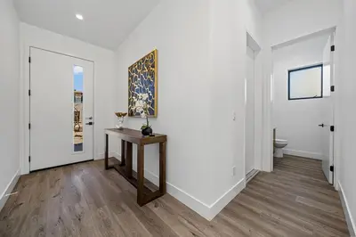 a hallway with white walls and a table with a painting at 5BR Gorgeous Melrose Villa with Parking in Los Angeles