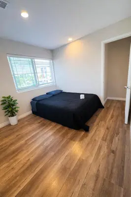 a bedroom with a bed and a wooden floor at Vernon Homes For The Soul in Los Angeles