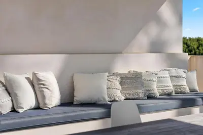 a row of white pillows sitting on a bench at Vibrant SoCal Venice Beach Retreat in Los Angeles