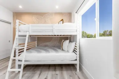 a bedroom with two bunk beds and a window at Modern 3BR Retreat with Rooftop Deck Sleeps 8 in Los Angeles