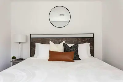 a bedroom with a white bed with a mirror on the wall at Upscale 4BR Townhouse Sleeps 8 with Fast WiFi in Los Angeles