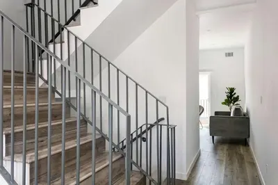 a staircase in a home with white walls and wood floors at Upscale 4BR Townhouse Sleeps 8 with Fast WiFi in Los Angeles
