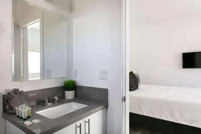 a bathroom with a sink and a large mirror at Upscale 4BR Townhouse Sleeps 8 with Fast WiFi in Los Angeles