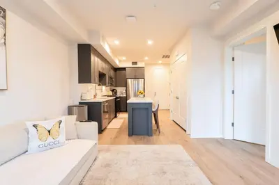 a living room with a white couch and a kitchen at Hollywood Palladium 1 BD EV charger Free Parking in Los Angeles