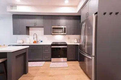 a kitchen with gray cabinets and a stainless steel refrigerator at Hollywood Palladium 1 BD EV charger Free Parking in Los Angeles