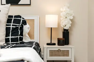 a bedroom with a bed and a table with a lamp at Stylish Glendale Retreat by Americana & Galleria in Glendale
