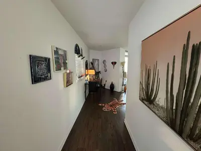 a hallway with paintings on the walls of a house at Walk to Beach & Promenade Cozy Santa Monica Condo in Los Angeles