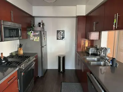 a kitchen with a stainless steel refrigerator and a sink at Walk to Beach & Promenade Cozy Santa Monica Condo in Los Angeles