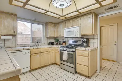 a kitchen with wooden cabinets and a stove top oven at Golf, Fish and More! Peaceful Home in Helendale in Helendale