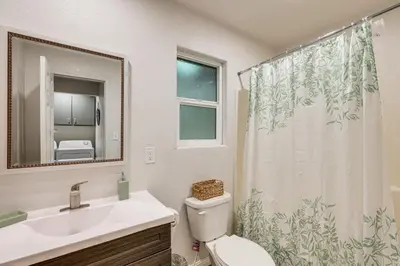 a bathroom with a sink and a toilet and a shower curtain at 1 Mi to Lake Gregory! Updated Family Home with Deck in Crestline