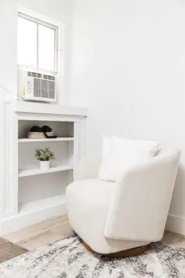 a white chair in a living room with a window at Peaceful 2BD Home in WeHo in Los Angeles