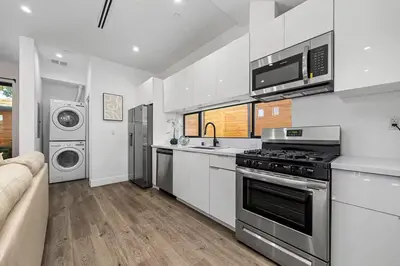 a white kitchen with a stove and a microwave at 2BR 2BA Villa in Melrose with Free Parking in Los Angeles