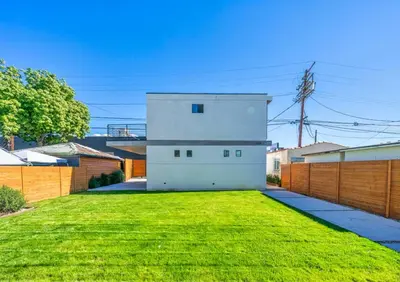 a white house in a yard with green grass at 2BR 2BA Villa in Melrose with Free Parking in Los Angeles