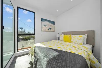 a bedroom with a bed and a large window at 7 BR double house with parking and a backyard in LA in Los Angeles