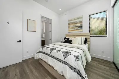 a white bedroom with a bed and a window at 7 BR double house with parking and a backyard in LA in Los Angeles