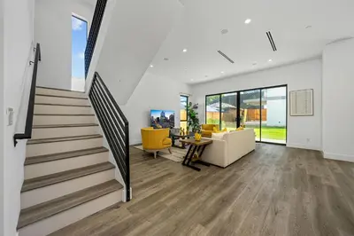 a living room with a staircase and yellow chairs at 7 BR double house with parking and a backyard in LA in Los Angeles