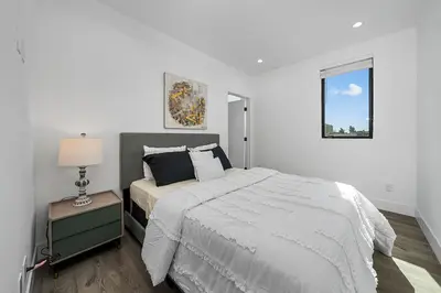 a white bedroom with a bed and a lamp at 7 BR double house with parking and a backyard in LA in Los Angeles