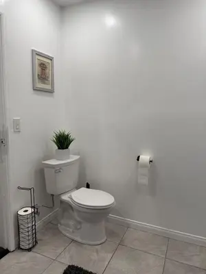 a bathroom with a toilet with a plant on the wall at Modern2BR Home SoFi LAX Parking Fast WiFi in Los Angeles