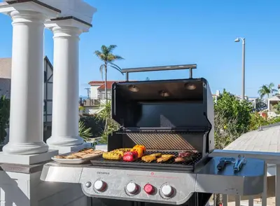a barbecue grill with a plate of food on it at 4br Beach House Steps from Beach with AC Parking BBQ in Hermosa Beach
