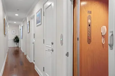 a hallway with white walls and a wooden door at 4br Beach House Steps from Beach with AC Parking BBQ in Hermosa Beach