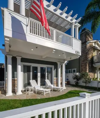a house with white chairs and an american flag at 4br Beach House Steps from Beach with AC Parking BBQ in Hermosa Beach