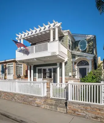 a house with an american flag on a balcony at 4br Beach House Steps from Beach with AC Parking BBQ in Hermosa Beach