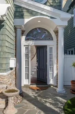an arched entryway to a house with a blue door at 4br Beach House Steps from Beach with AC Parking BBQ in Hermosa Beach